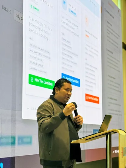 Hafiz Zainudin in a professional speaking engagement at a technology industry event, addressing an audience from stage