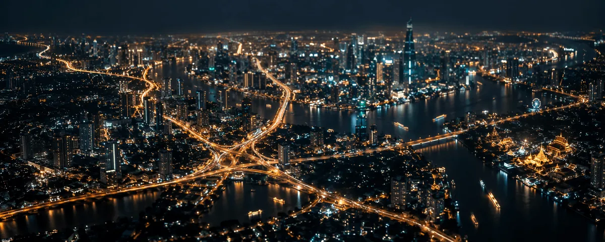 Long-exposure aerial night view of city light trails forming an abstract network of glowing amber nodes across a dark slate skyline